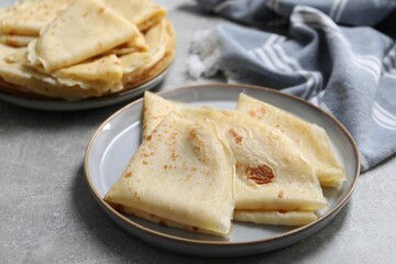 Tasty crepes on grey textured table, closeup