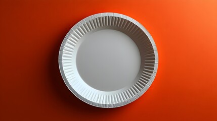 A white plate is sitting on a red background