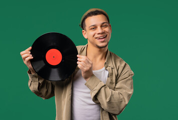 Stylish man with vinyl record disc on Yellow. Hobby, music lover, collection
