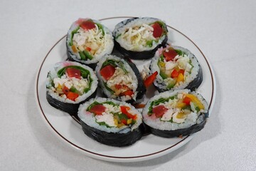 Delicious kimbap rolls filled with fresh vegetables, seasoned rice, and savory proteins, all wrapped in crisp seaweed. A perfect combination of flavor and texture in every bite.
