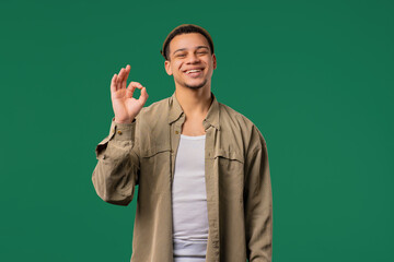 20s handsome man makes sign okay, ok gesture. Happy guy, correct perfect choice