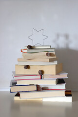 Christmas tree made with stack of books. Cute Christmas tree for booklovers. Selective focus.