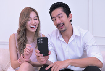 asian couple smiling on smartphone together