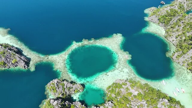 Aerial drone shot of the picturesque twin lagoon in Coron, surrounded by turquoise waters.