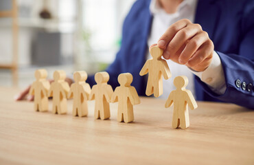 Close up shot of a male lawyer with wooden figures representing people group, symbolizing...
