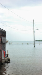 House partially submerged in water, likely due to flooding or rising sea levels. A poignant image of environmental impact and displacement.