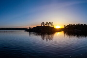 Sunset over tranquil lake with reflections.