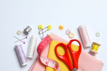 Flat lay composition with various sewing accessories on white backgroud