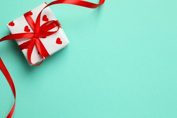 Gift box with red hearts on color  background