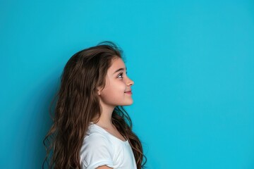 Fototapeta premium Attractive girl showcasing copy space on blue background.