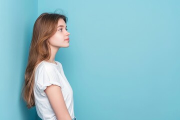 Fototapeta premium Attractive girl with copy space on blue background portrait.