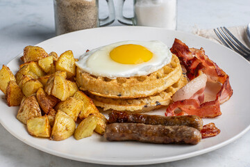 fried egg on waffles  with bacon and sausages,