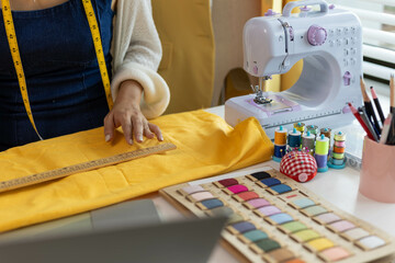 A woman who is running an online clothing business and is also a designer, working on designing...