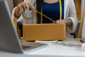 A woman who is running an online clothing business and is also a designer, working on designing...