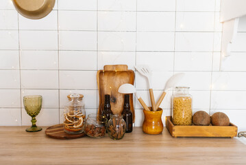 Kitchen counter with variety of items including wooden cutting board, bottle of wine, bottle...