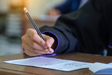 Asian students are taking exams to measure learning in the classroom. Soft and selective focus.