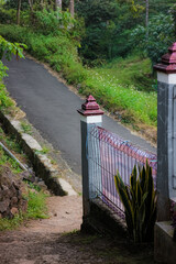 A vibrant pink and white fence post stands tall against a backdrop of lush green trees, adding a splash of color to the landscape.