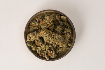 in a bowl dry flowers of medical cannabis. On a light background