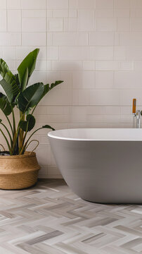 Une baignoire grise de style &eacute;pur&eacute; sur un parquet en chevron dans une salle de bain contemporaine.