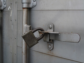 Photo shows a cargo van's back door being padlocked.