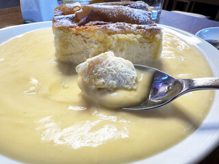 Creamy vanilla sauce with cheesecake slice and ice cream on spoon