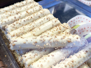 Creamy white chocolate-coated pretzel sticks with crunchy topping