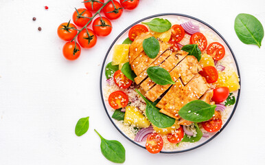Nourishing salad with grilled chicken, couscous, tomatoes, onion, spinach and orange. White background, top view