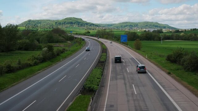 Transport traffic on two-way road on a sunny day. A two-lane road with six lanes of traffic each way. Germany.