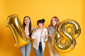 Coming of age party - 18th birthday. Group of young women celebrating with number shaped balloons...