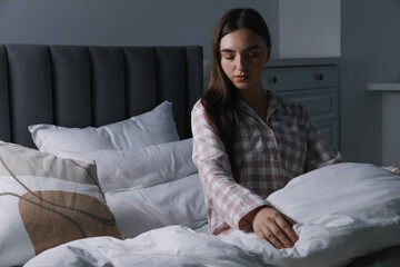 Young woman suffering from sleepwalking on bed at home