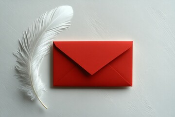 Red envelope and white feather on a white textured surface. Chinese New Year themed flat lay with copy space.