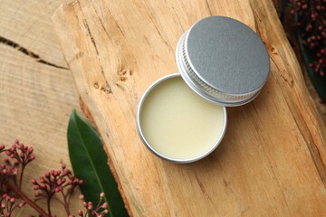 Natural solid perfume and skimmia plant on wood, top view. Space for text