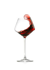 Red wine splashing in glass on white background