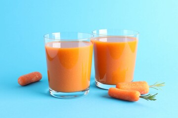 Fresh carrot smoothie in glasses and vegetables on light blue background, closeup