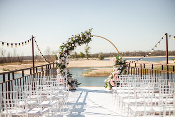 round arch of white flowers and greenery on the background of nature. wedding day