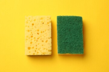 Soft sponges on yellow background, top view. Cleaning tool