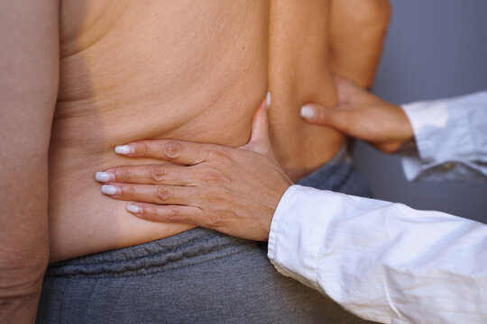 Senior man receiving therapeutic back massage for relief