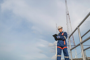 Engineer in Full Safety Gear Climbing a Ladder to Inspect Communication Signals and Industrial Machinery at a High-Risk Transportation Facility