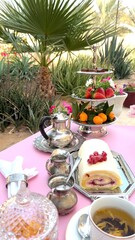 Naklejka premium Creamy cake roll placed next to cup on wooden table, ornate silver tray adding rustic elegance. Cup and cake together enhance outdoor dessert ambiance. Wooden display concept.