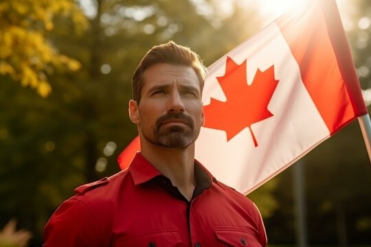 Canadian man wearing red shirt is holding a waving flag of canada