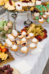 table with desserts. In the foreground is a glass plate with small tartlets