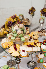 table with desserts. In the foreground is a glass plate with small tartlets