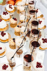 festive table with sweet snacks in cups