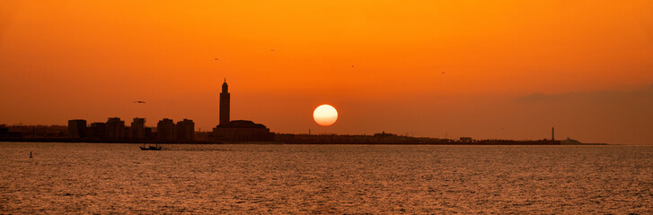 Panoramic view of the water front of Casablanca right before sunset. The minaret of the Hassan II...