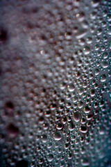 Close Up of Condensation Floating Liquid Water Bubbles and Drips on Glass from Rain