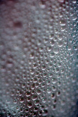 Close Up of Condensation Floating Liquid Water Bubbles and Drips on Glass from Rain