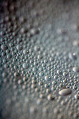 Close Up of Condensation Floating Liquid Water Bubbles and Drips on Glass from Rain