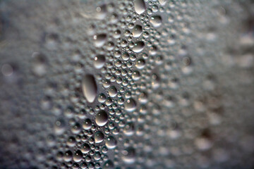 Close Up of Condensation Floating Liquid Water Bubbles and Drips on Glass from Rain