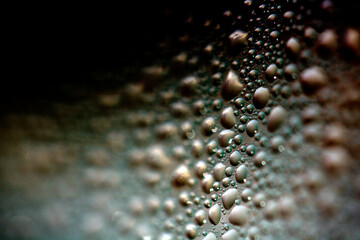 Close Up of Condensation Floating Liquid Water Bubbles and Drips on Glass from Rain