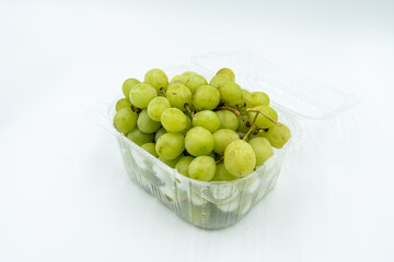 Fresh green grapes in clear plastic container, healthy snack option